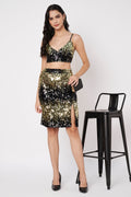 Woman wearing a black and gold sequin outfit with a stool in the background